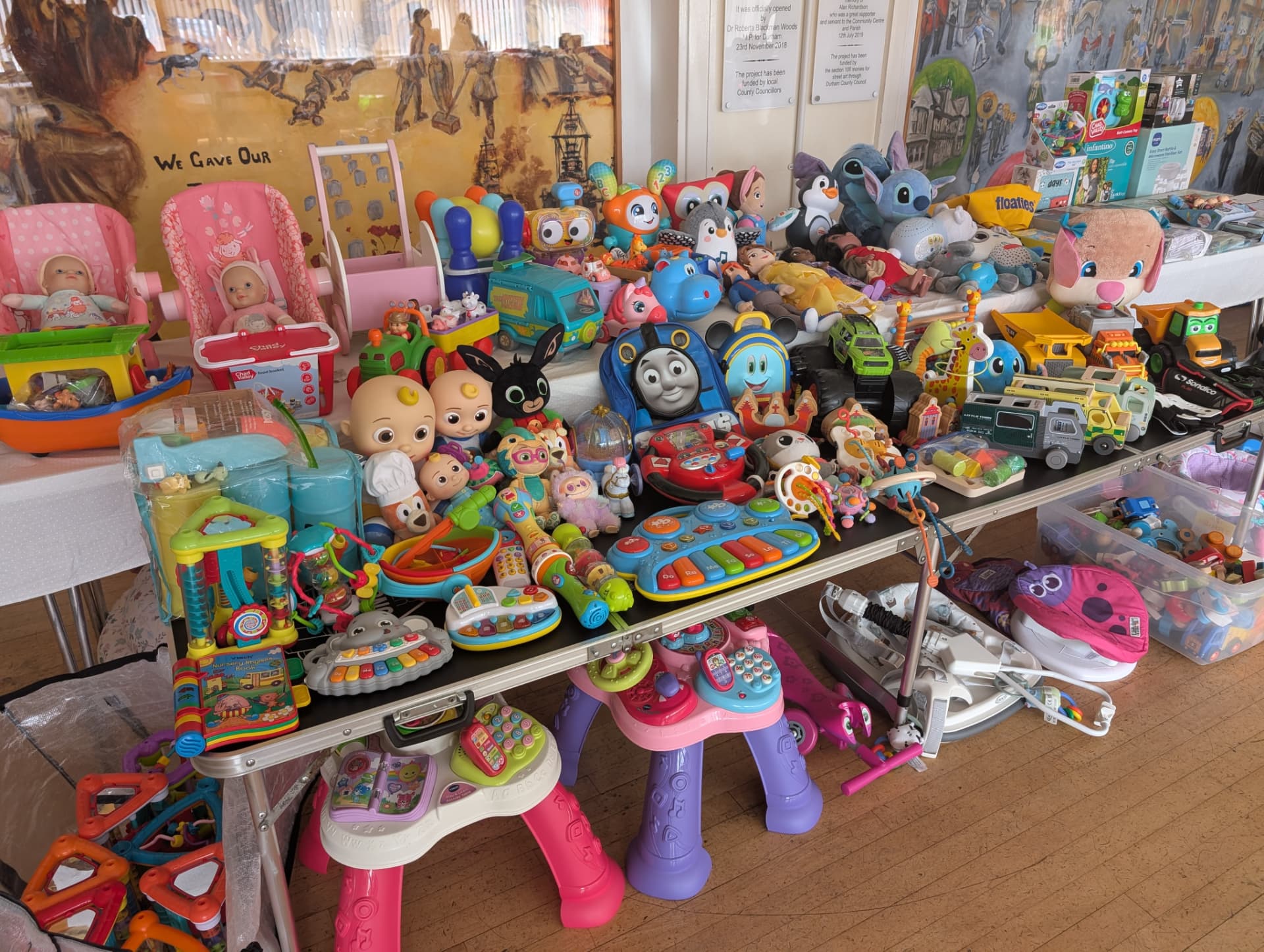 A preloved stall laid out with colourful children's toys and clothes